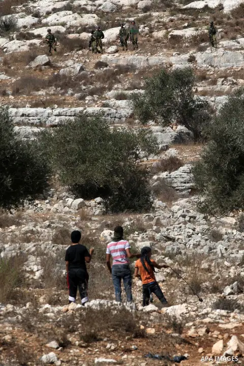 Palestinian boys throw stones at Israeli soldiers during clashes over the Jewish settlement of Qadomem at Kofr Qadom village, near West Bank city of Nablus, 19 September 2014. Palestinians are repeatedly protesting at th...