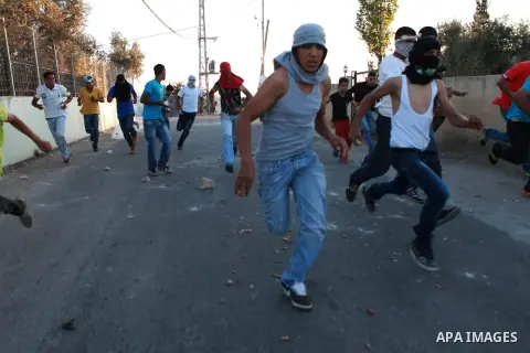 Palestinian protesters run for cover during clashes with Israeli security forces at a protest against the Jewish settlement of Ofra, in the West Bank village of Silwad, near Ramallah September 19, 2014. Photo by Shadi Ha...