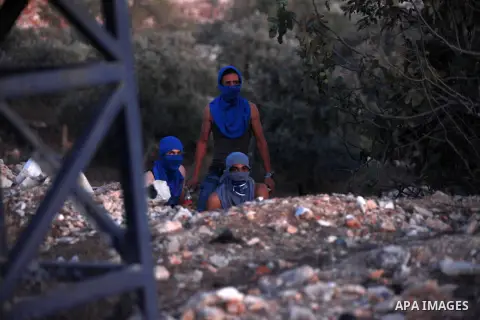 A Palestinian protester throws stones towards Israeli security forces during clashes at a protest against the Jewish settlement of Ofra, in the West Bank village of Silwad, near Ramallah September 19, 2014 . Photo by Sha...