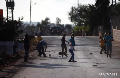 Palestinian protesters throw stones towards Israeli security forces during clashes at a protest against the Jewish settlement of Ofra, in the West Bank village of Silwad, near Ramallah September 19, 2014 . Photo by Shadi...