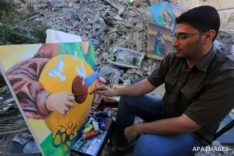 Palestinian Artists reside effectiveness and take part in paint with drawing in front of the El-Basha Tower which destroyed by Israeli airstrike in Gaza city on Sep. 20, 2014. Photo by Mohammed Asad