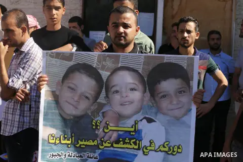 Palestinians hold pictures of their missing relatives during a protest, in Gaza city on Sept. 21, 2014. Gazans are missing after one of the deadliest migrant shipwrecks on record, a boat, with 500 people on board, was in...