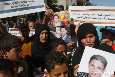 Palestinians hold pictures of their missing relatives during a protest, in Gaza city on Sept. 21, 2014. Gazans are missing after one of the deadliest migrant shipwrecks on record, a boat, with 500 people on board, was in...
