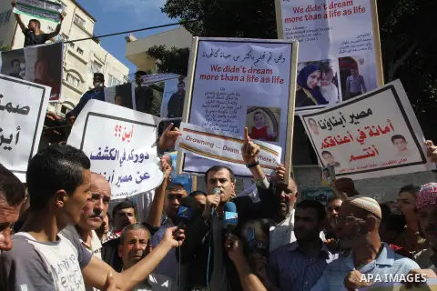 Palestinians hold pictures of their missing relatives during a protest, in Gaza city on Sept. 21, 2014. Gazans are missing after one of the deadliest migrant shipwrecks on record, a boat, with 500 people on board, was in...