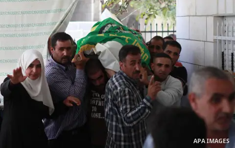 The mother of Amar Abu Aysha, a Palestinian shot dead by Israeli troops, reacts in front of her son's body during his funeral in the West Bank city of Hebron September 23, 2014. Israeli troops shot dead two Palestinians,...