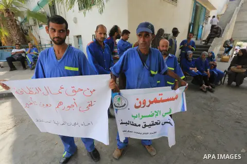 Palestinian clean workers hold banners during a protest to demand for pay their salaries, in Gaza City September 24, 2014. Photo by Mohammed Asad