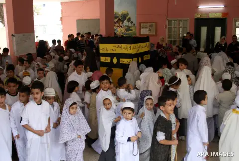 Palestinian children gather around a makeshift cube representing the holy Kaaba in the West Bank city of Nablus, on Sept. 30, 2014, as part of training children how to perform Hajj pilgrimage. Muslims from around the wor...