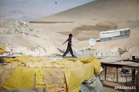 A Palestinian Bedouin boy plays at his family's dwellings, in the West Bank village of Al-Eizariya, near east of Jerusalem, on Septemper 30, 2014. Israel's Civil Administration in the West Bank is advancing a plan to exp...