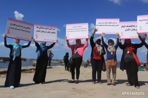 Palestinian women hold banners during the Breast Cancer Awareness campaign at Gaza port in Gaza City on Oct. 01, 2014. Photo by Mohammed Asad