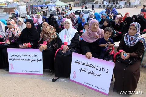 Palestinian women hold banners during the Breast Cancer Awareness campaign at Gaza port in Gaza City on Oct. 01, 2014. Photo by Mohammed Asad