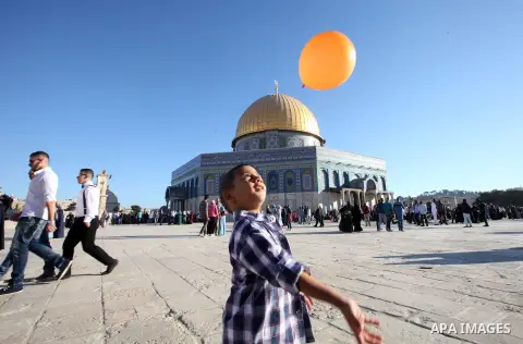 A Palestinian boy plays in front of the Dome of the Rock at the compound al-Aqsa mosque in Jerusalem's Old city on the first day of Eid al-Adha, October 04, 2014. Muslims around the world celebrate Eid al-Adha to mark th...