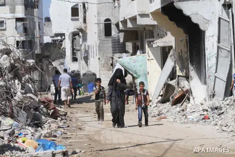Palestinians walk on a street near the rubble of houses that were destroyed during the seven-week Israeli offensive, in the Shejaia neighborhood east of Gaza City October 5, 2014, on the second day of the Muslim Eid al-A...