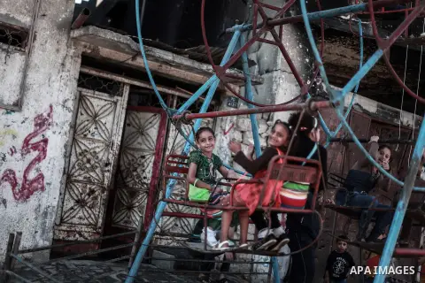 Palestinian children play on a swing in celebration of Eid al-Adha at al-Shijaiyah neighborhood in Gaza city on October 7, 2014. Muslims worldwide celebrate Eid al-Adha, the Feast of Sacrifice, to celebrate the end of th...