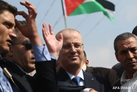 Palestinian Prime Minister Rami Hamdallah waves to media upon his arrival to the Gaza Strip at Erez Crossing checkpoint, northern Gaza Strip on October 9, 2014. The Palestinian unity government which took the oath of off...