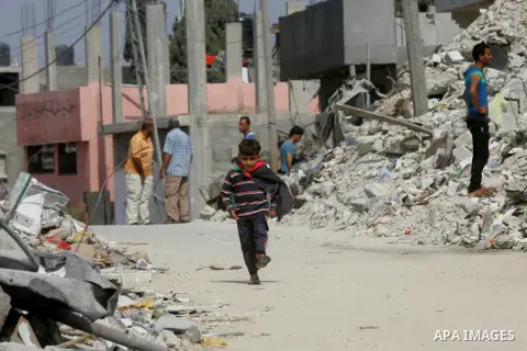 A Palestinian boy wears his national flag as Prime Minister Rami Hamdallah arrives to the Beit Hanoun in the northern Gaza Strip on October 9, 2014. The Palestinian unity government which took the oath of office in June...