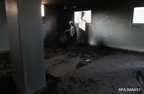 A Palestinian Muslim cleric inspects the inside of a mosque burnt by Jewish settlers, in the village of Aqraba, in the Israeli occupied Palestinian West Bank, near the northen city of Nablus, on October 14, 2014. The wor...