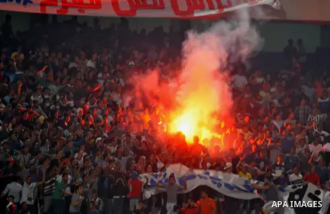Egyptian soccer fans known as "Ultras" shout slogans against the government and police while holding a flare during the African Nations Cup qualifying soccer match between Egypt and Botswana, in Cairo October 15, 2014. T...