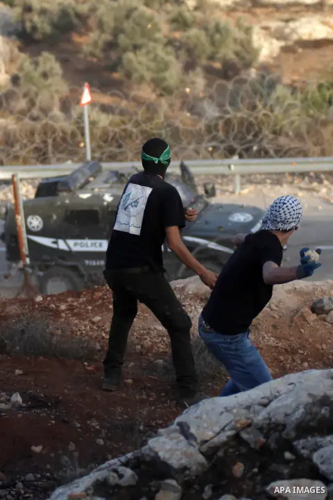 Palestinian protesters throw stones towards Israeli security forces during clashes at a protest to show solidarity with al-Aqsa mosque, outside Israel's Ofer military prison near the West Bank city of Ramallah October 17...