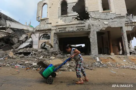 A Palestinian girls fills containers with water in Shejaia neighborhood, that witnesses said was devastated during a seven-week Israeli offensive, in the east of Gaza City October 19, 2014. An open-ended ceasefire betwee...