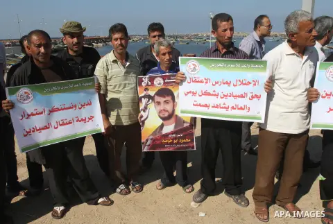 Palestinian fishermen hold banners during a protest against the arrest of fishermen at the seaport of Gaza City on Oct. 23, 2014. Israeli forces detained five Gaza fishermen off the coast of Gaza City early Wednesday, an...