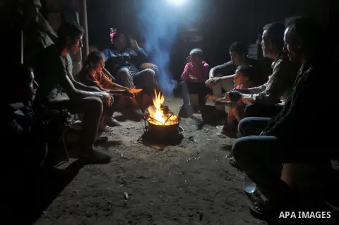 Palestinians warm themselves around a fire, at their destroyed house in al-Shejaiya neighbourhood in the east of Gaza City, October 23, 2014. With the cold days of winter approaching, more than 100,000 Gaza residents are...