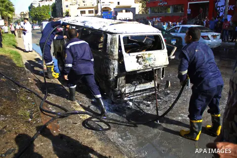 Egyptian workers try to extinguish the fire in a bus was burned by supporters of Muslim Brotherhood and ousted president Mohammed Morsi, during a protest against military rule, in Cairo on October 24, 2014. Photo by Amr...
