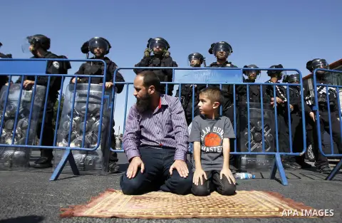 Palestinians pray as Israeli police stand guard during Friday prayers in the Arab east Jerusalem neighbourhood of Ras al-Amud October 24, 2014. Israeli police declared an age limit on Friday for Palestinians wanting to e...