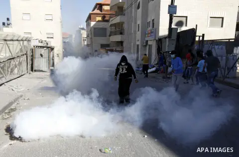 Palestinian protesters run from tear gas fired by Israeli police during clashes in the east Jerusalem neighbourhood of Issawiya October 24, 2014. Tension in Jerusalem rose on Wednesday after an Israeli baby died and eigh...