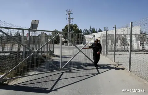 A Palestinian security officer closes the gate under Palestinian control at the Rafah border crossing with Egypt in the southern Gaza Strip October 25, 2014. The decision was taken to close the Rafah crossing into the Ga...