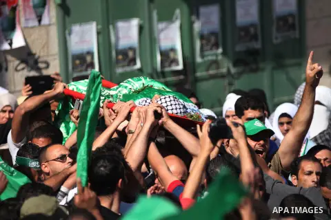 Mourners carry the body of Palestinian-American youth Orwah Hammad, whom medics said was killed by Israeli forces, during his funeral in the West Bank village of Silwad near Ramallah October 26, 2014. Israeli forces shot...