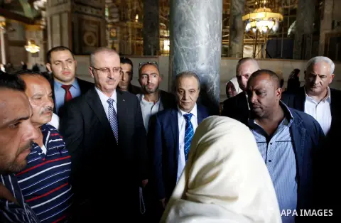 Palestinian prime minister Rami Hamdallah, speaks with a Palestinan woman during a visit to the al-Aqsa mosque compound, Islam's third holiest site, on October 27, 2014. An Israeli plan to build more than 1,000 new homes...