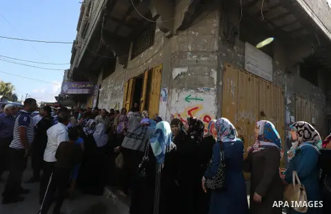 Employees of former Palestinian government in Gaza Strip wait to receive their salaries at a Post Office in Gaza city on October 29, 2014. The Palestinian national unity government headed by prime minister Rami Hamdallah...
