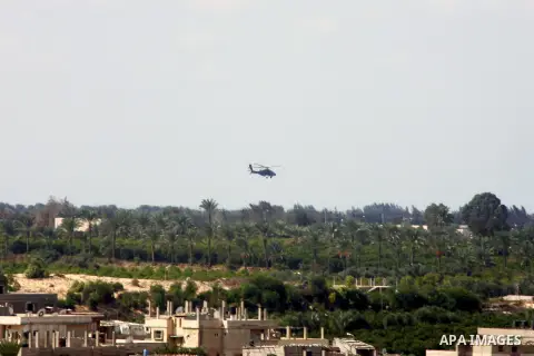 An Egyptian military helicopter hovers over the borders during a military operation to demolish some buildings in the Egyptian city of Rafah near the border with southern Gaza Strip October 29, 2014, as Egypt began setti...