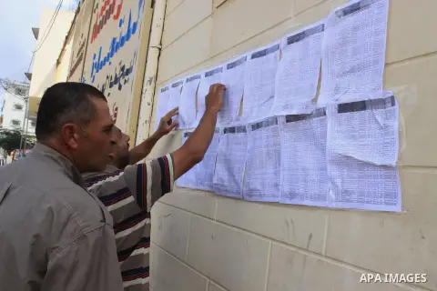 A Palestinian man, whose house was partially damaged by what witnesses said was Israeli shelling during the most recent conflict between Israel and Hamas, looks for his name to receive bags of cement outside a store in t...