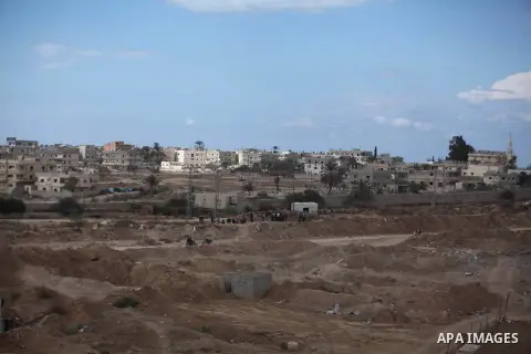 Palestinians look on as Egyptian soldiers take part in a military operation in the Egyptian city of Rafah, near the border with the southern Gaza Strip on October 30, 2014, as Egypt began setting up a buffer zone along t...