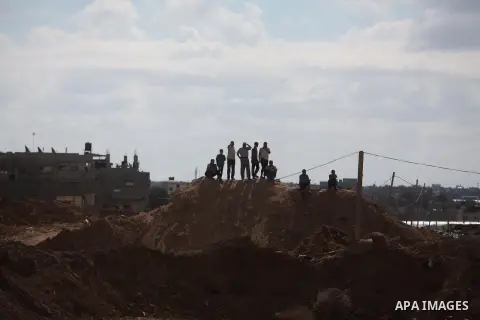 Palestinians look on as Egyptian soldiers take part in a military operation in the Egyptian city of Rafah, near the border with the southern Gaza Strip on October 30, 2014, as Egypt began setting up a buffer zone along t...