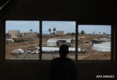 A Palestinian man looks on as Egyptian soldiers take part in a military operation in the Egyptian city of Rafah, near the border with the southern Gaza Strip on October 30, 2014, as Egypt began setting up a buffer zone a...
