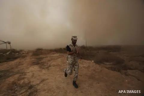 A Palestinian security officer runs as smoke rises after a house is blown up during a military operation by Egyptian security forces in the Egyptian city of Rafah, near the border with the southern Gaza Strip on October...