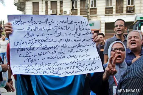 Pro-deposed president Hosni Mubarak Egyptians hold placards during a protest demanding the trial of the revolution leaders, outside the court of cassation, in Cairo on October 30, 2014. Photo by Amr Sayed