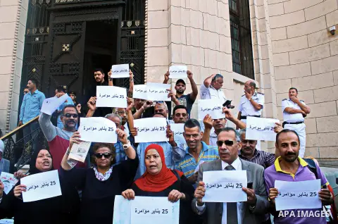 Pro-deposed president Hosni Mubarak Egyptians hold placards during a protest demanding the trial of the revolution leaders, outside the court of cassation, in Cairo on October 30, 2014. Photo by Amr Sayed