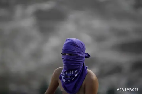 A masked Palestinian youth looks on during clashes with Israeli security forces after Moataz Higazi was shot in east Jerusalem October 30, 2014. Israeli police shot and killed Higazi suspected of trying to kill a hard-li...