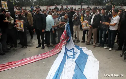 Palestinians burn a U.S flag and an Israeli flag during an anti-Israel rally organised by the Islamic Jihad movement over the entry restrictions to the al-Aqsa mosque, in Gaza City October 31, 2014. Muslim men over 50 pr...