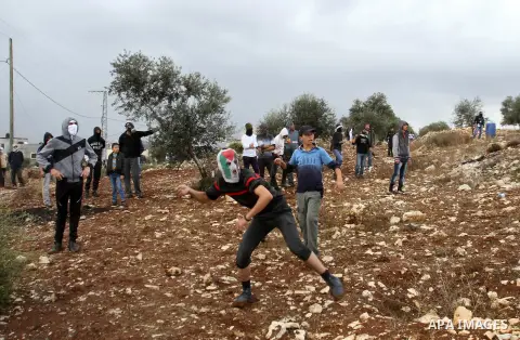 Palestinian protesters throw stones towards Israeli security forces during clashes following a weekly demonstration against the expropriation of Palestinian land by Israel in the village of Kafr Qaddum, near Nablus, in t...