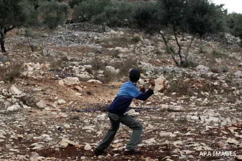 A Palestinian protester throws stones towards Israeli security forces during clashes following a weekly demonstration against the expropriation of Palestinian land by Israel in the village of Kafr Qaddum, near Nablus, in...