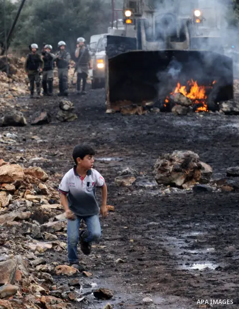 A Palestinian boy runs during clashes with Israeli security forces following a weekly demonstration against the expropriation of Palestinian land by Israel in the village of Kafr Qaddum, near Nablus, in the occupied West...