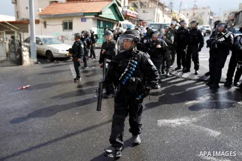 Israeli security forces stand guard as Palestinian Muslim worshippers (unseen) perform traditional Friday prayers on a street outside the Old City in east Jerusalem on October 31, 2014, following restrictions by Israeli...