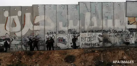 Members of Israeli security forces fire tear gas towards Palestinian demonstrators during clashes at the Qalandia checkpoint between Ramallah and Jerusalem City following a rally by supporters of the Hamas movement again...