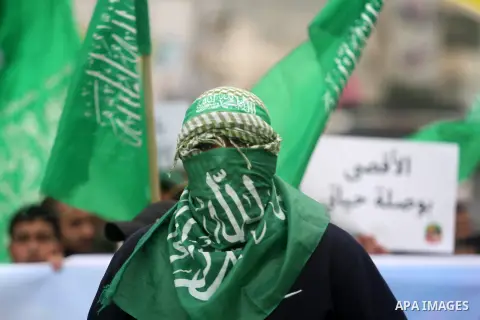 A Palestinian supporter of Hamas holds tha movement's flag during a demonstration against the restrictions on the Al-Aqsa mosque compound, at the Qalandia checkpoint between Ramallah and Jerusalem City on October 31, 201...