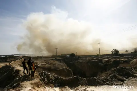 Palestinians look on as Egyptian soldiers take part in a military operation in the Egyptian city of Rafah, near the border with the southern Gaza Strip on Nov. 01, 2014, as Egypt began setting up a buffer zone along the...
