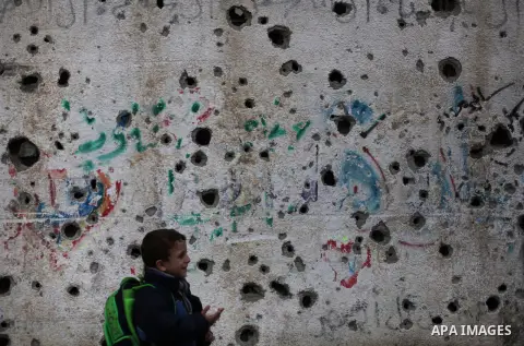 A Palestinian boy stands near the ruins of a wall that witnesses said was destroyed by Israeli shelling during the most recent conflict between Israel and Hamas, on a rainy day in the east of Gaza City November 3, 2014....